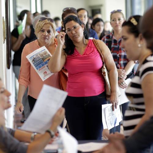 Reina Borges left stands in line to apply for a job with Aldi at a job fair in Miami Lakes Fla. On Friday Aug. 5 the Labor Department issues its jobs report for July