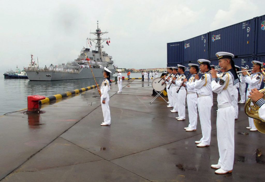 A Chinese military band plays as the guided missile destroyer USS Benfold arrives in port in Qingdao in eastern China's Shandong Province Monday Aug. 8 2016. A U.S. Navy guided missile destroyer arrived in the northern Chinese port of Qingdao on Monday