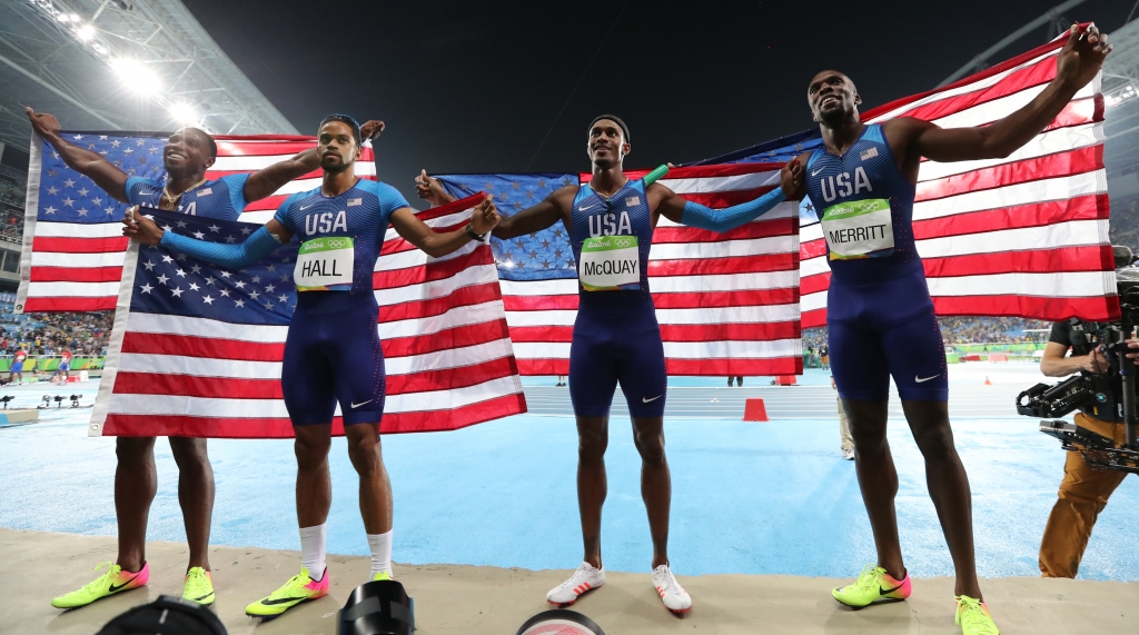 The United States men's 4x400 meter relay team Arman Hall Tony McQuay Gil Roberts and La Shawn Merritt celebrate winning the gold medal holding their nation's flag during athletics competitions at the Summer Olympics inside Olympic stadium