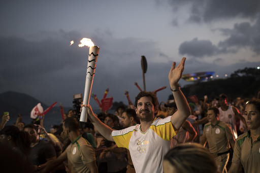 The Latest Olympic flame arrives in Rio on tour boat