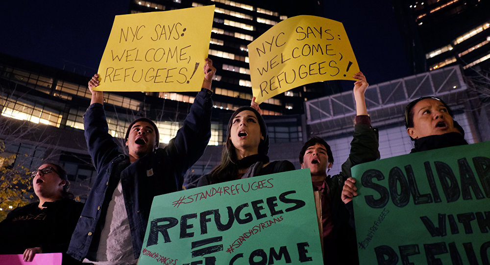 Human rights activists and people from the Muslim community display placards during a demonstration in New York in solidarity for Syrian and Iraqi refugees