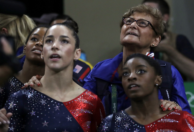 Marta Karolyi U.S. gymnastics team coordinator looks at the scoreboard along with from right Simone Biles Aly Raisman and Gabrielle Douglas during the