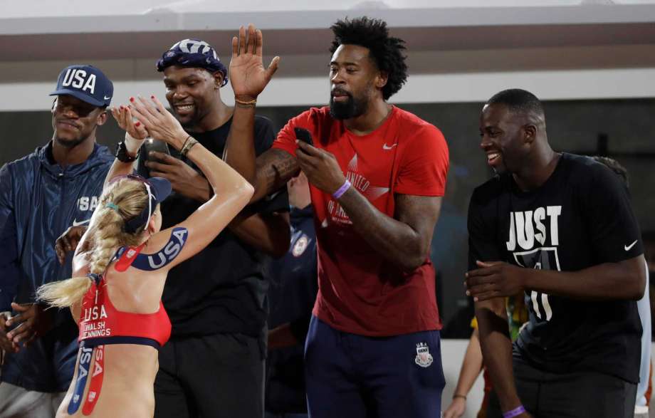 United States Kerri Walsh Jennings celebrates with members of United States basketball team from left Jimmy Butler Kevin Durant De Andre Jordan and Draymond Green after winning a women's beach volleyball quarterfinal match against Australia at the 20