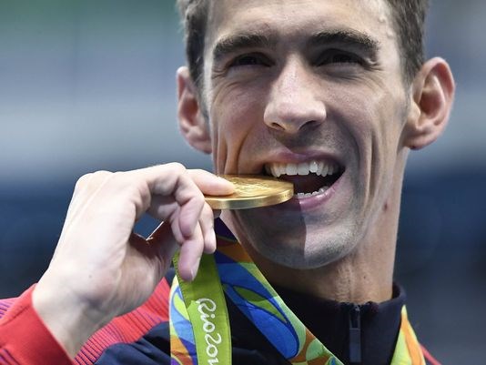 USA's Michael Phelps kisses his gold after Team USA won the men's 4x200m Freestyle Relay Final in Rio