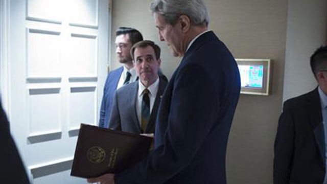 Secretary of State John Kerry speaks to senior adviser John Kirby before a news conference in Vienna. The State Department says a $400 million cash payment to Iran was contingent on the release of American