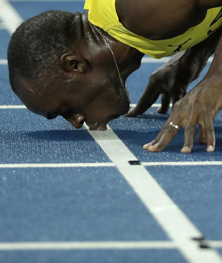 Usain Bolt from Jamaica kisses the track after crossing the line to win the gold medal in the men's 200-meter final during the athletics competitions of the 2016 Summer Olympics at the Olympic stadium in Rio de Janeiro Brazil