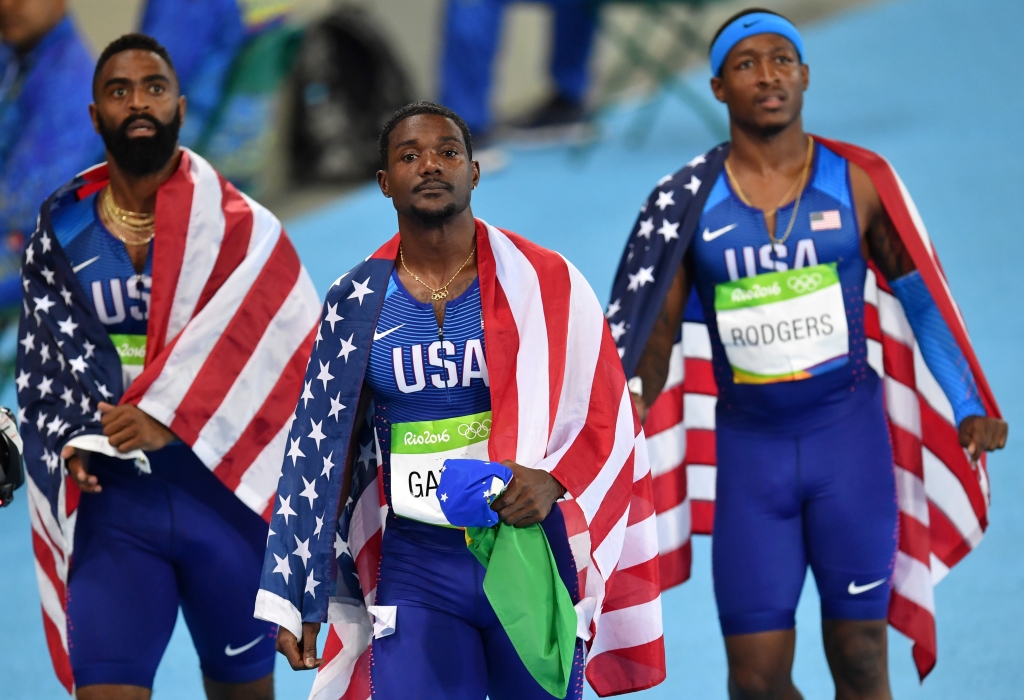 USA's Tyson Gay USA's Justin Gatlin and USA's Michael Rodgers react after being disqualified of the Men's 4x100m Relay Final during the athletics event at the Rio 2016 Olympic Games at the Olympic Stadium in Rio de Janeiro on A