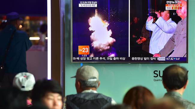 People watch a television screen reporting news of North Korea's latest submarine-launched ballistic missile test at a railway station in Seoul South Korea