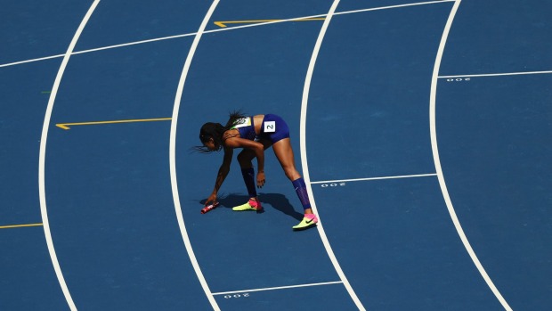 Allyson Felix of the United States picks up the baton to hand it to English Gardner after it was dropped