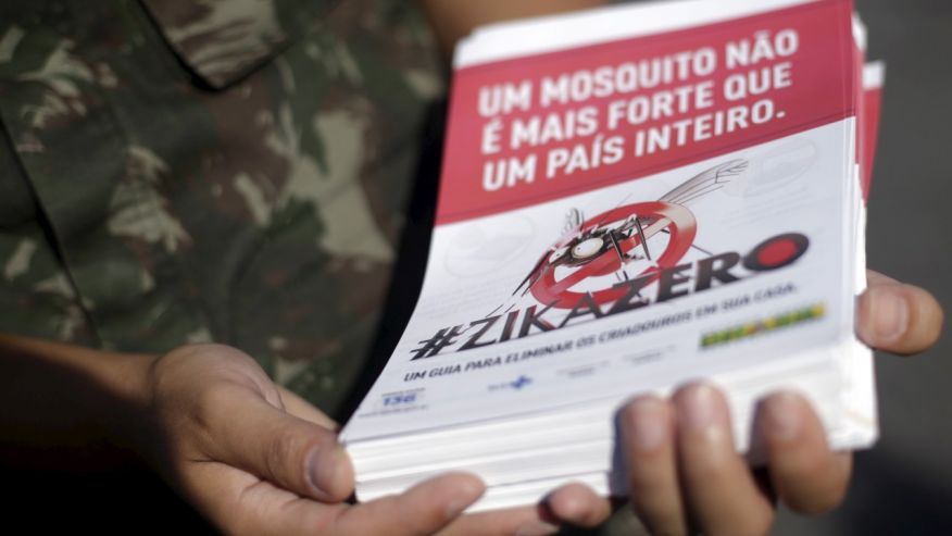 A Brazilian Army soldier shows a pamphlet which will be distributed in the city after a ceremony to mark the graduation from training on how to combat the Aedes aegypti mosquito in Rio de Janeiro Brazil