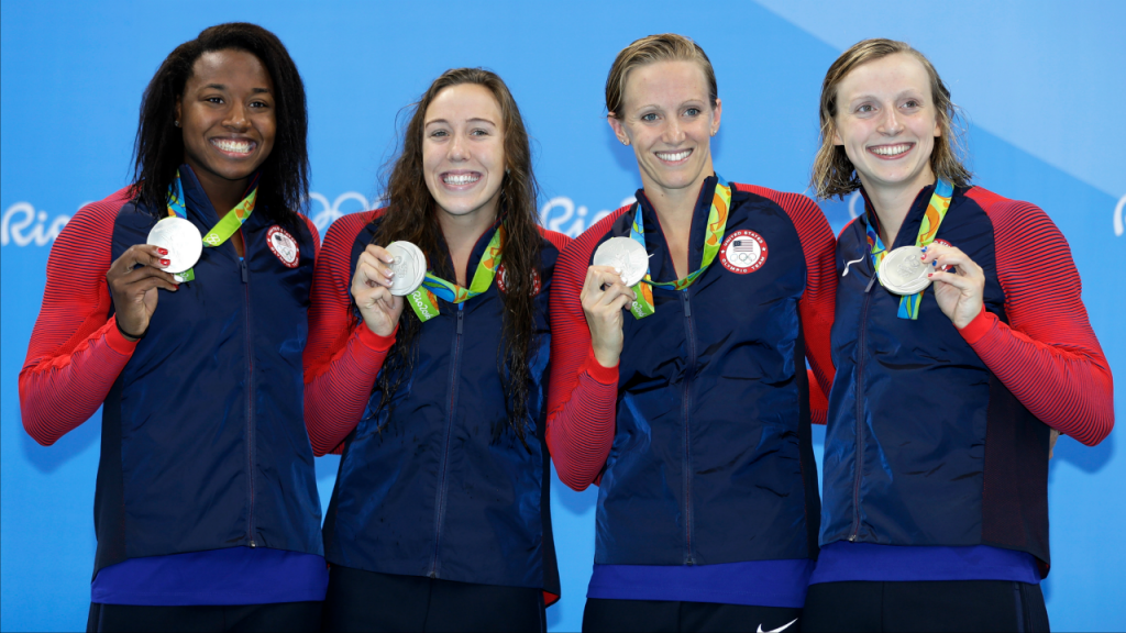 Simone Manuel Abbey Weitzeil Dana Vollmer and Katie Ledecky show off their silver medals during the ceremony for the women's 4x100-meter freestyle final during the swimming competitions at the 2016 Summer Olympics