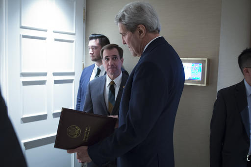 Secretary of State John Kerry speaks to senior adviser John Kirby before a news conference in Vienna. The State Department says a $400 million cash payment to Iran was contingent on the release of American