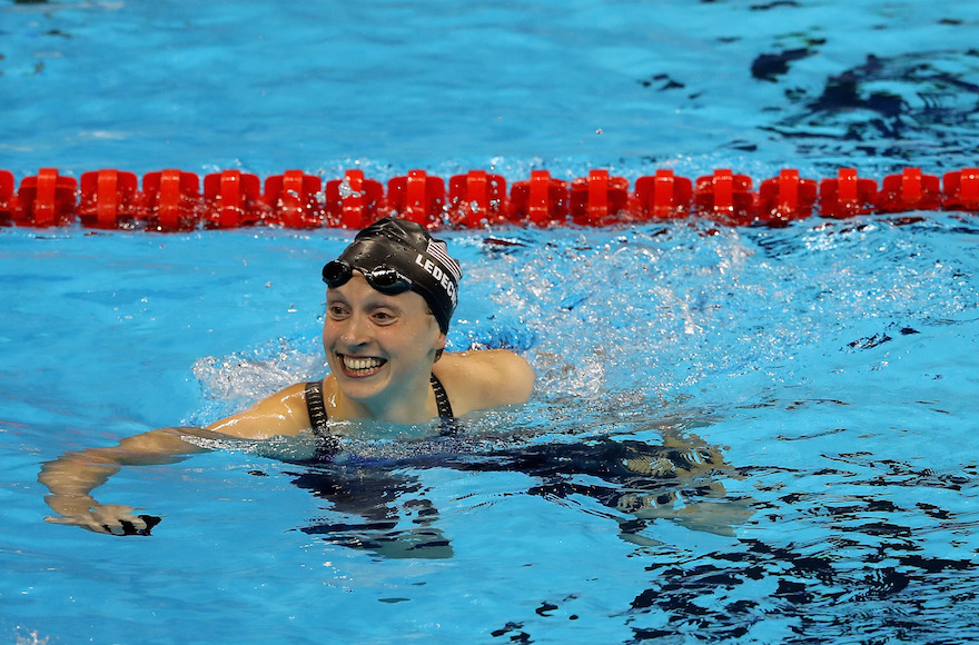 Katie Ledecky celebrating winning gold and setting a new world record in the Women's 400-meter freestyle final on day two of the Rio 2016 Olympic Games at the Olympic Aquatics Stadium Aug. 7 2016