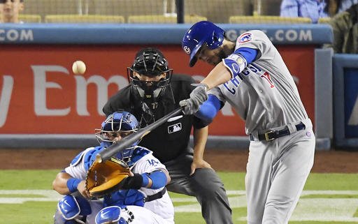 Chicago Cubs Kris Bryant hits a two-run home run as Los Angeles Dodgers catcher Carlos Ruiz left watches along with home plate umpire Alfonso Marquez during the 10th inning of a baseball game Friday Aug. 26 2016 in Los Angeles. (AP