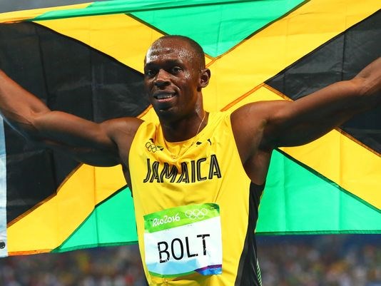 Usain Bolt celebrates winning the men's 200 meters for the third consecutive Games