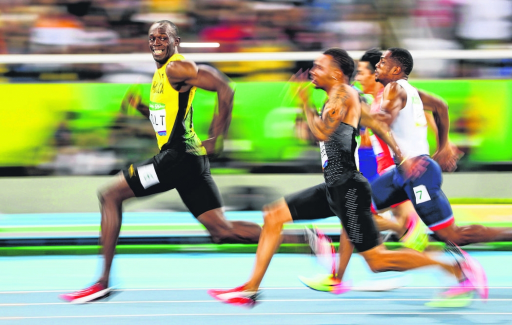 Usain Bolt of Jamaica looks at Andre De Grasse of Canada during the men's 100m semifinal race