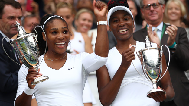 Venus Williams of The United States and Serena Williams of The United States hold up their trophies following victory in the Ladies Doubles Final in July 2016