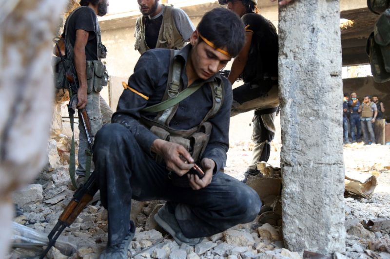 A rebel fighter reloads during clashes with regime forces in Ramussa on the edge of Aleppo