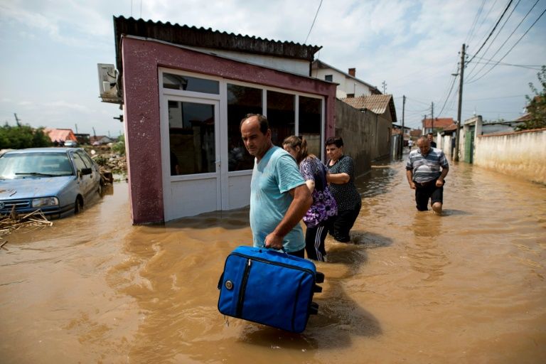 People leave their flood-hit homes in the village of Stajkovci near Macedonia capital Skopje