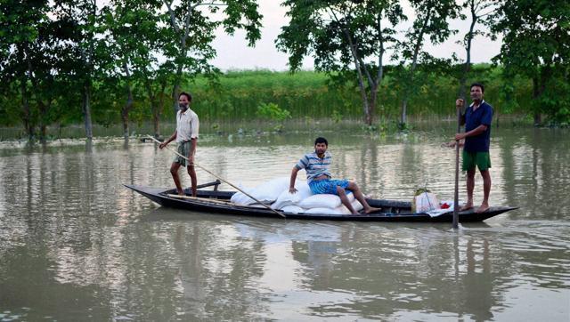 Villagers carrying flood relief items on a country boat in flood-affected Pasahbari,30 km from Guwahati in Assam