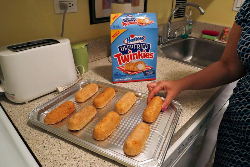 Associated Press reporter Anne D'Innocenzio arranges frozen deep-fried Twinkies on a tray before baking in New York