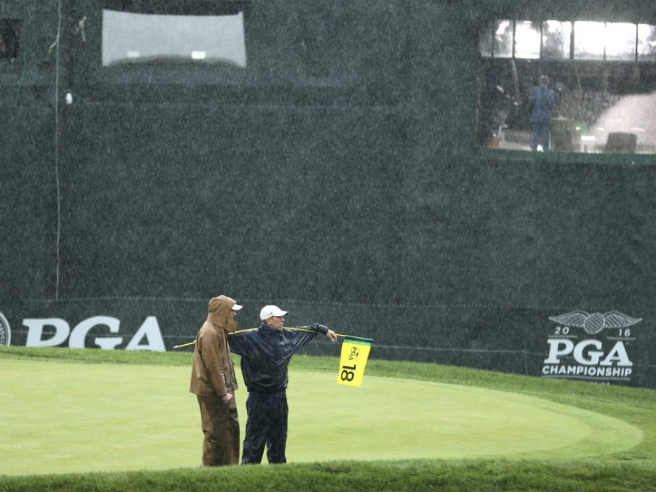 Members of the grounds crew stand on the 18th green during a weather delay in the third round of the PGA Championship at Baltusrol Golf Club in Springfield N.J. on Saturday