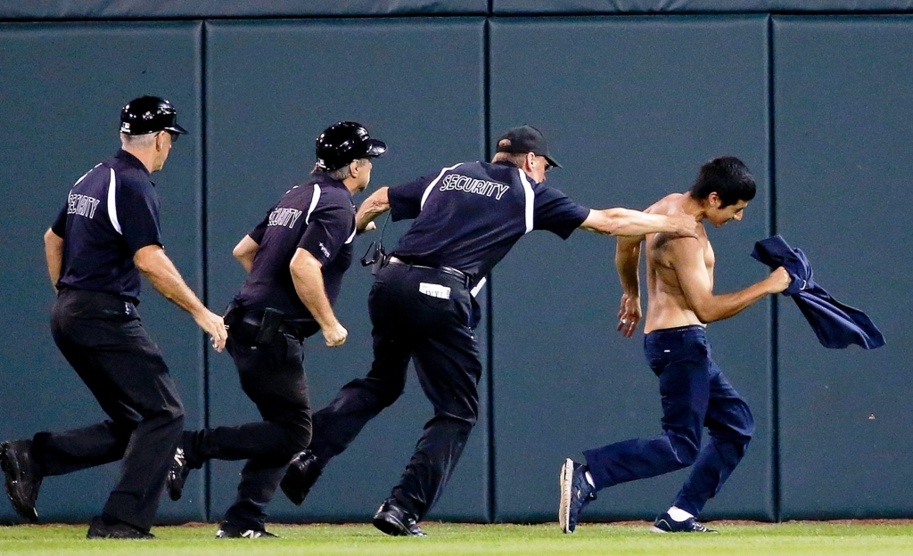 White Sox security apprehends one of the fans who ran onto the field against the Mariners