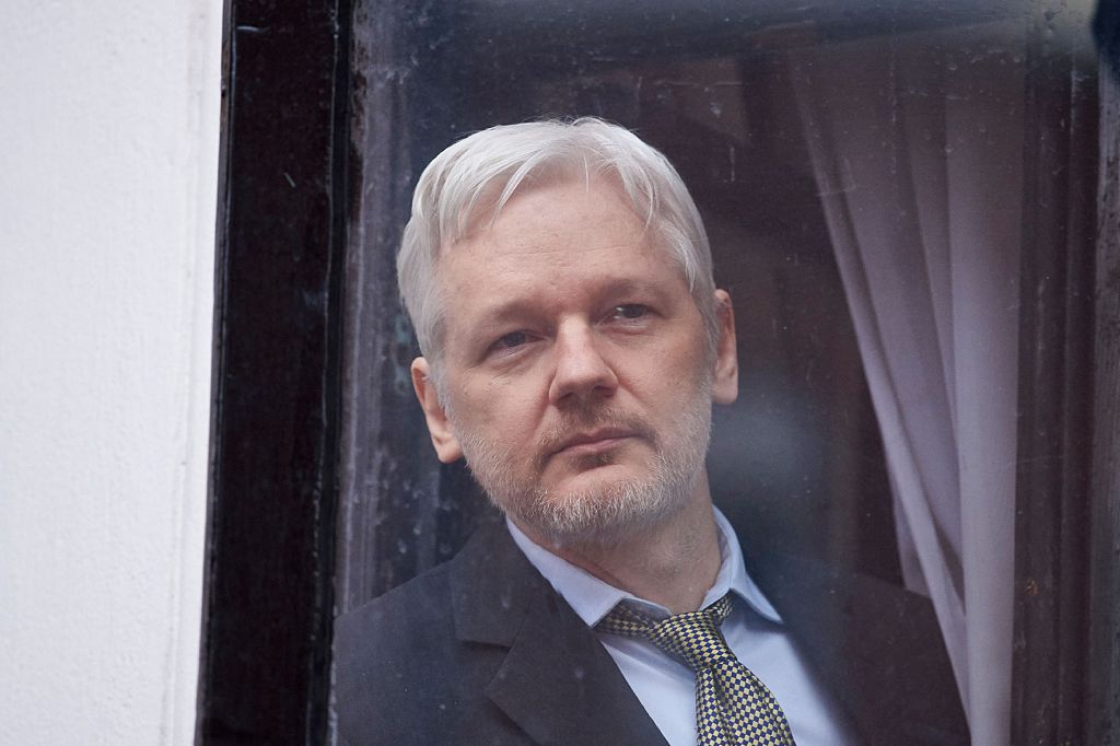 WikiLeaks founder Julian Assange is seen through the window of the door leading to the balcony of the Ecuadorian embassy in central London