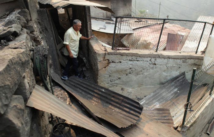 Avelino Viveiros visits his house that burned yesterday at Curral dos Romeiros during the forest fires in Funchal Madeira island Portugal on Wednesday. — Reuters