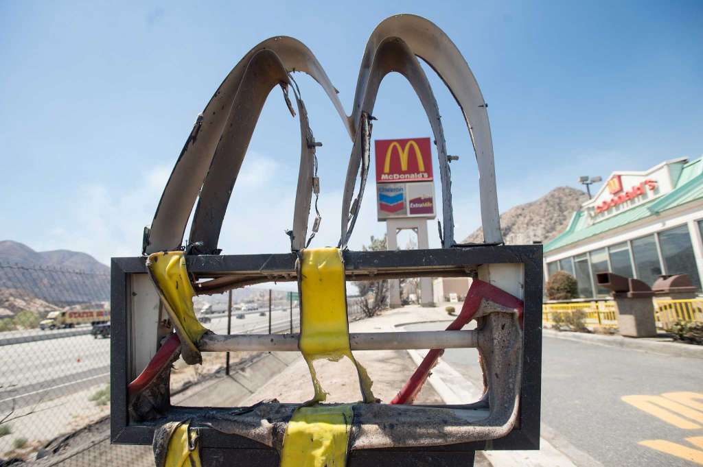 Following a wildfire a melted McDonald's sign stands outside a restaurant in Cajon Junction Calif. on Thursday Aug. 18 2016. Scenes of destruction were everywhere Thursday after a huge wildfire sped through mountains and high desert 60 miles east