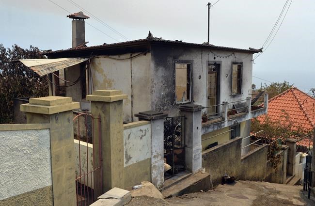 A burnt house stands in Alto da Pena on the outskirts of Funchal the capital of Portugal's Madeira island Wednesday Aug. 10 2016. Three people died in their homes Tuesday night when the neighborhood was reached by the forest fires that are raging