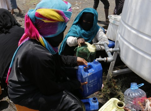 Women displaced by the fighting in Yemen collect water at a camp fin the northern province of Amran Yemen 10 August 2016