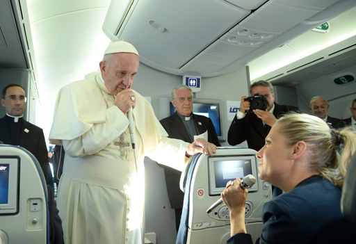 Pope Francis speaks with a journalist during a press conference on the plane after his visit to Krakow for the World Youth Days