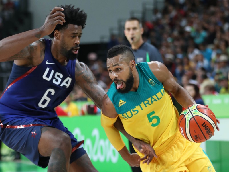 RIO DE JANEIRO Aug. 10 2016 Patty Mills of Australia drives the ball against De Andre Jordan from the United States of America during a men's preliminary round match of basketball at the 2016 Rio Olympic Games in Rio de Janeiro Brazil on Aug