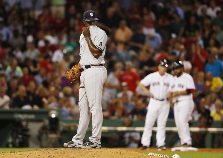 Yankees starting pitcher Luis Severino wipes his face after giving up a triple to Red Sox's Sandy Leon in the fifth inning