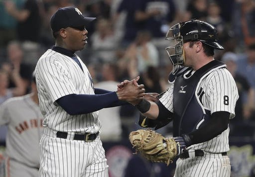 New York Yankees relief pitcher Aroldis Chapman left shakes hands with catcher Austin Romine after the Yankees defeated the San Francisco Giants 3-2 in a baseball game Friday