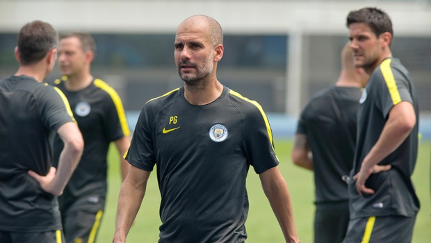 Manchester City manager Pep Guardiola center leaves the field after his team's training session at the Olympic Sports Center Stadium in Beijing Sunday