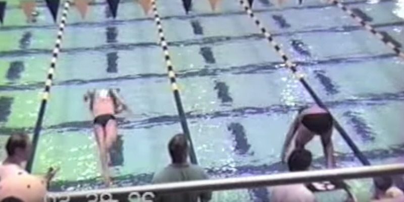 An 11-year-old Michael Phelps dives into the water during a 50 m butterfly race in 1997