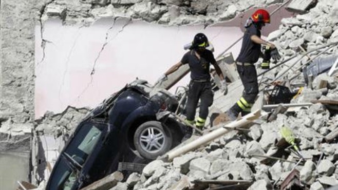 Rescuers make their way through destroyed houses following Wednesday's earthquake in Pescara Del Tronto Italy Thursday Aug. 25 2016. Rescue crews raced against time Thursday looking for survivors from the earthquake that leveled three towns in