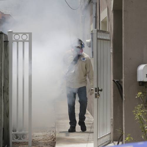 Dade County mosquito control worker sprays around a home in the Wynwood area of Miami on Monday Aug. 1 2016. The CDC has issued a new advisory that says pregnant women should not travel a Zika-stricken part of Miami and pregnant women