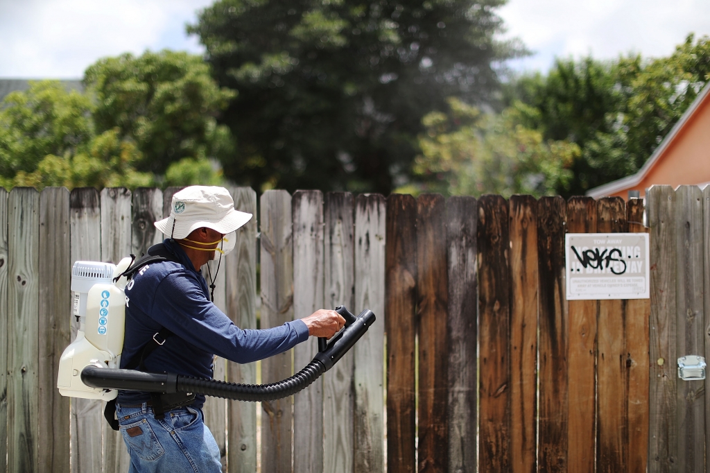 A Miami Dade County mosquito control inspector uses a fogger to spray pesticide to kill mosquitoes to control the Zika virus outbreak