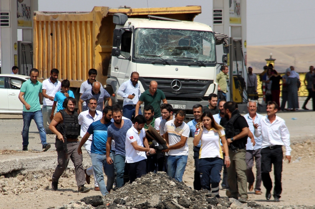 Paramedics and other people carry away a body after an explosion at a police station near the city of Diyarbakir southeastern Turkey Monday Aug. 15 2016. Kurdish rebels detonated a car bomb at the police station killing two police officers and a young