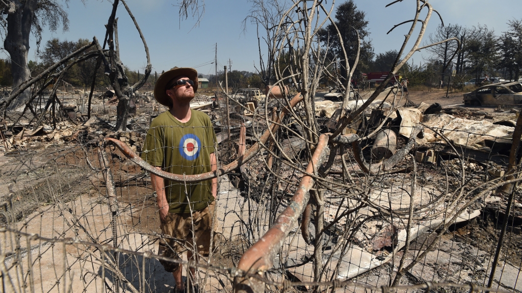 James Mc Cauley looks over the burned-out remains of his residence in the town of Lower Lake Calif