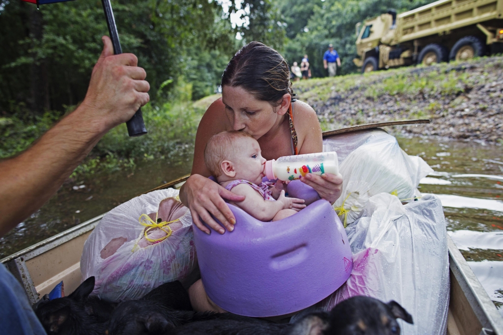 Danielle Blount kisses her 3-month-old baby Ember as she feeds her while they wait to be evacuated by members of the Louisiana Army National Guard near Walker La. after heavy rains inundating the region Sunday Aug. 14 2016. (Max Becherer  Associated