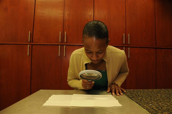 Savannah Hawes the 482nd Fighter Wing installation public health administrator uses a magnifying glass to examine mosquitoes she captured around Homestead Air Reserve Base Fla. Hawes is examining the mosquitoes she finds to see if they carry the Zika