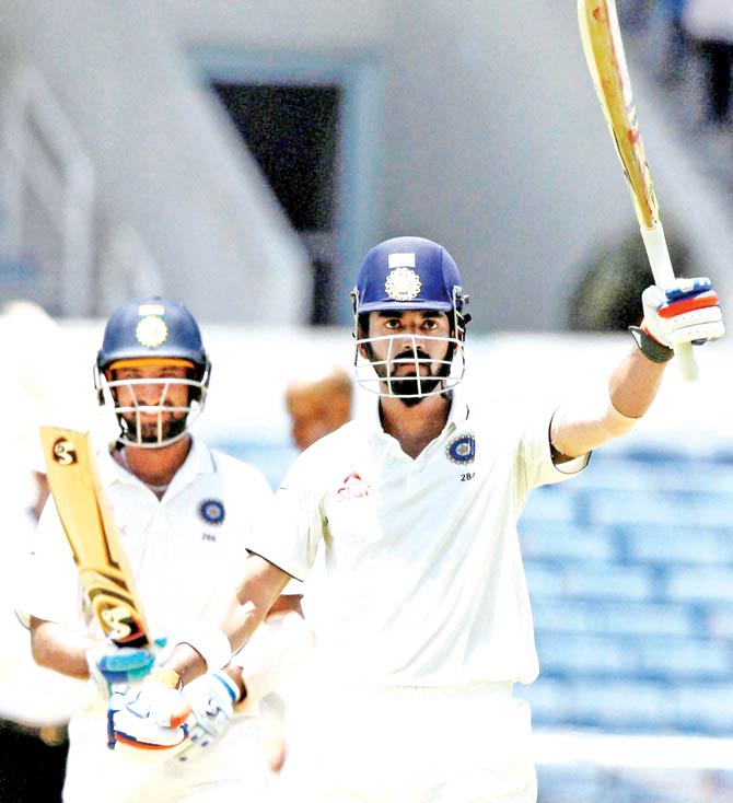 India's Lokesh Rahul celebrates his century as partner Cheteshwar Pujara looks on during the first session of Day Two in the second Test against West Indies at Sabina Park Kingston yesterday. Pic  PTI