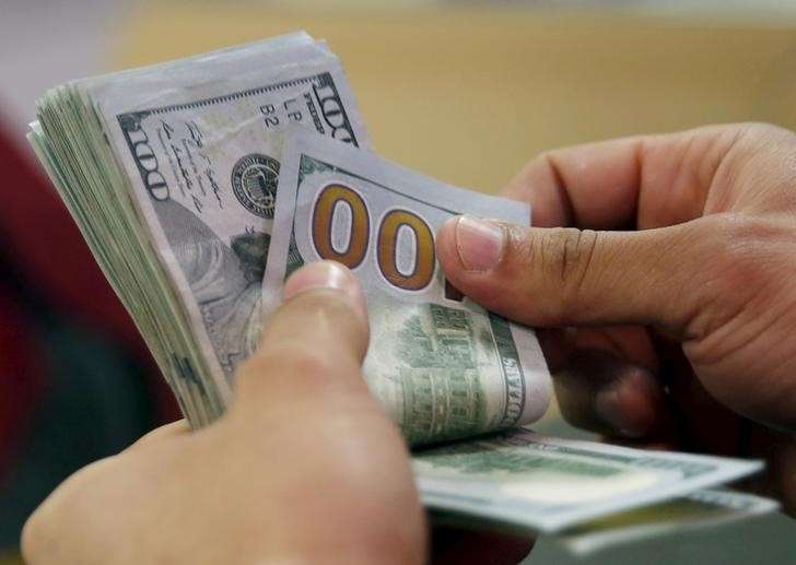 A customer counts his U.S. dollar money in a bank in Cairo Egypt