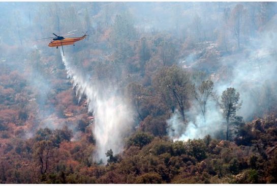 A work crew from the California Conservation Corps Butte County Fire Center cuts a line on Black Mountain near the town of Tollhouse Calif. while fighting a blaze Monday Aug. 1 2016