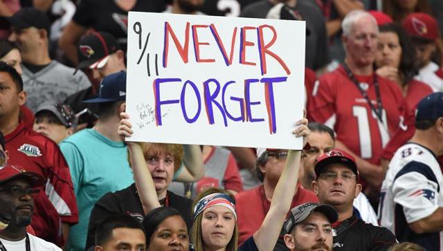 A New England Patriots fan holds up a sign to honour the victims of the 9/11 attacks during a game at the University of Phoenix Stadium on Sunday