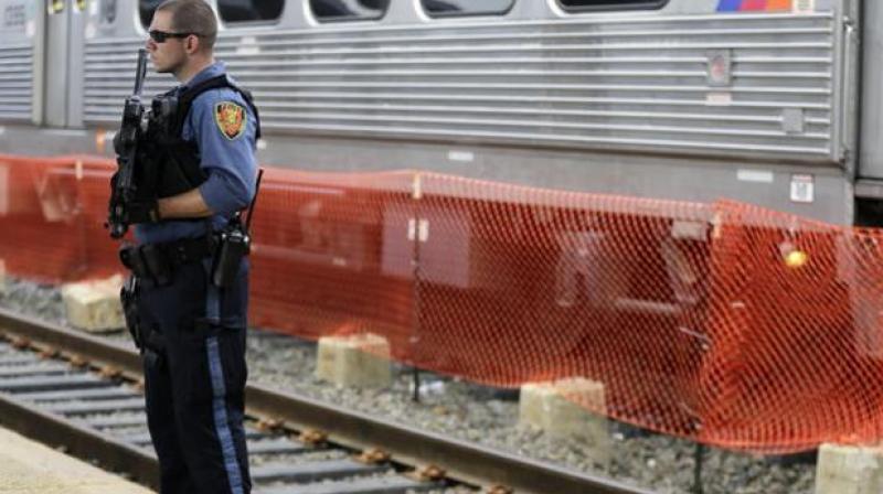 A New Jersey Transit Police officer stands guard near a train in New Jersey